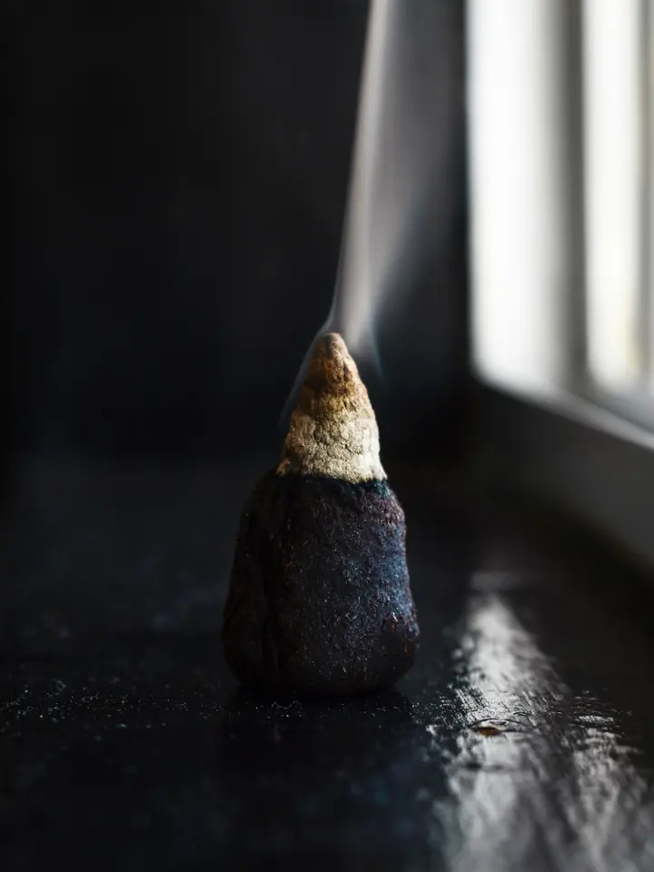 An incense cone smoking beside a window