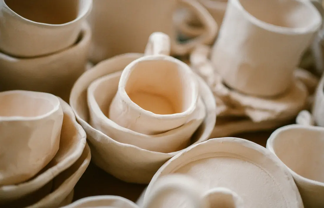 A pile of white dishes sitting on top of a table