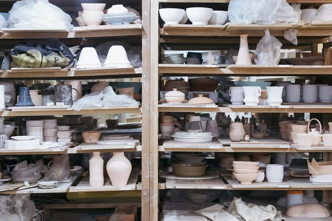 White ceramic teacup on brown wooden shelf